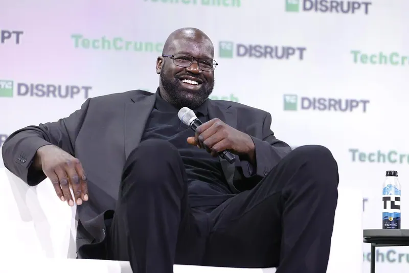 Shaquille O'Neal, seated and smiling, speaks into a microphone onstage at TechCrunch Disrupt 2023 at Moscone Center, San Francisco.